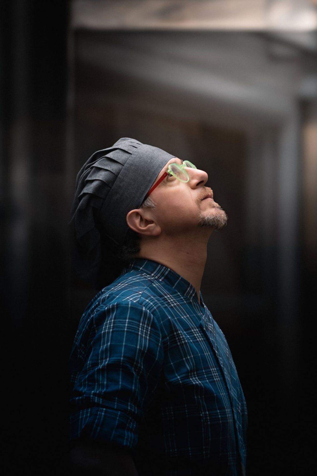Ritratto di Giovanni Santarpia di profilo con cappello da pizzaiolo e occhiali.